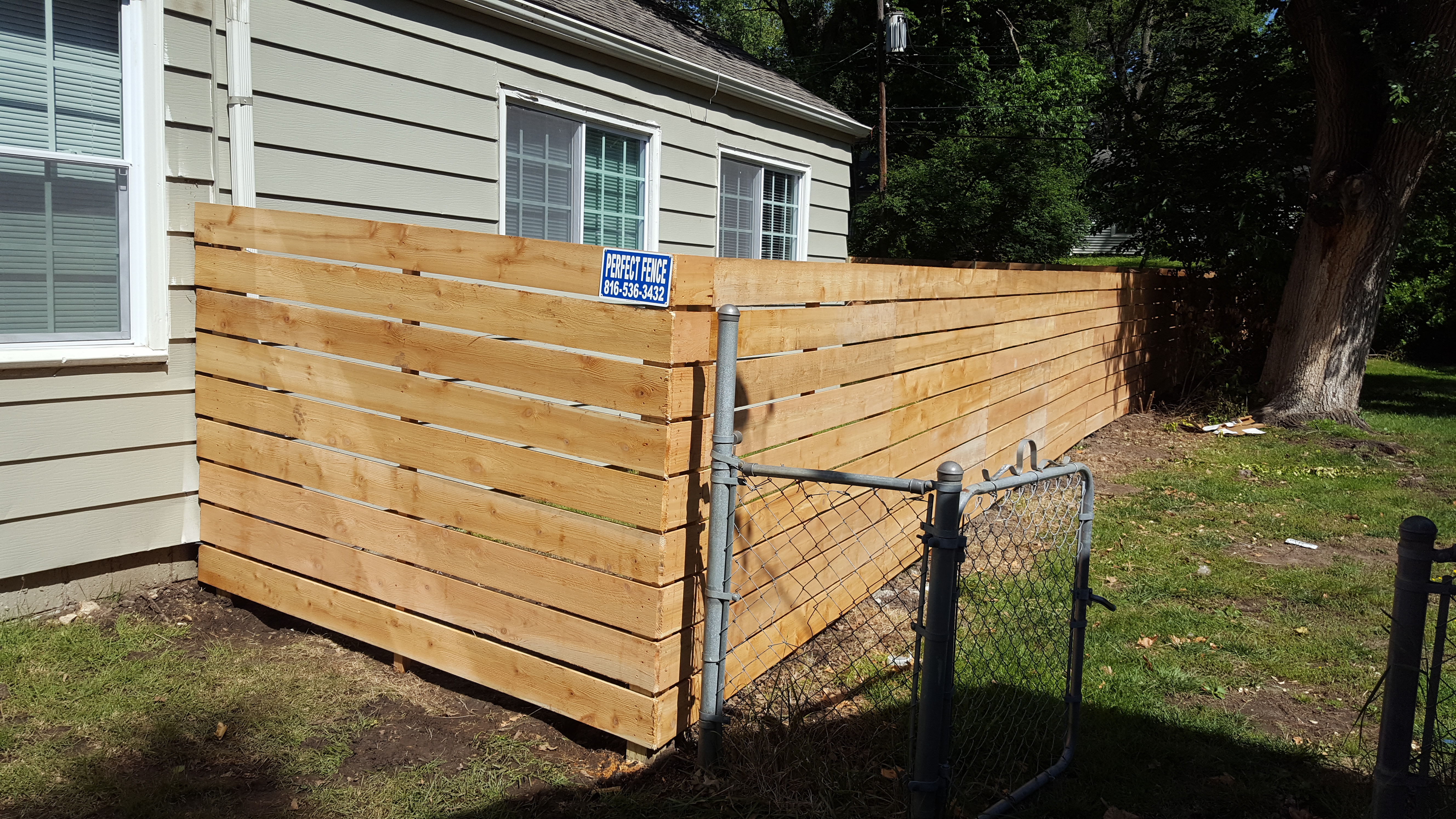 Horizontal cedar picket fence with 1" spacing.