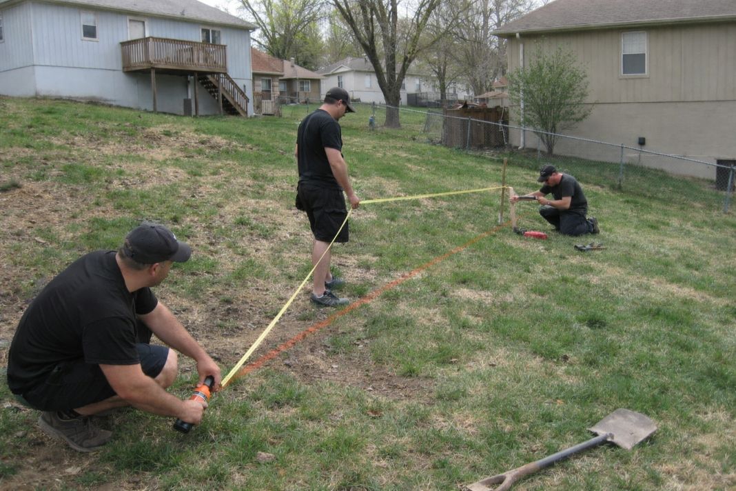 AI photo of team measuring and marking the fence line