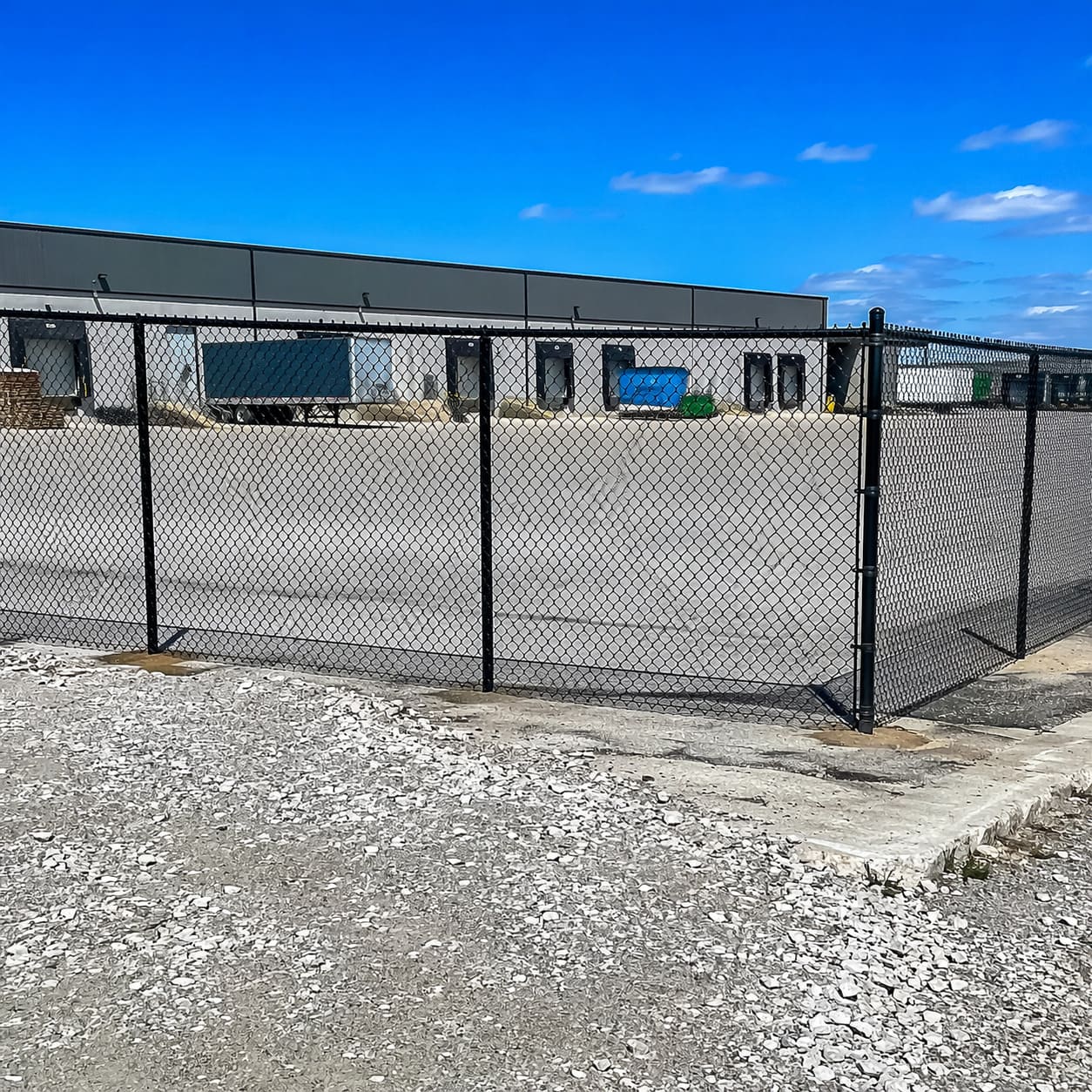 Commercial and Industrial Fence – Chain link perimeter fence surrounding warehouse yard – Sample Image